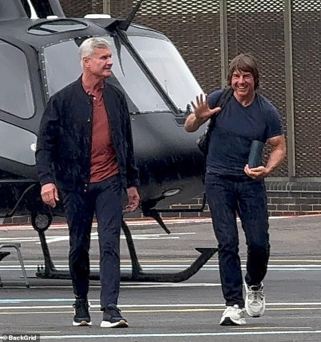 Tom Cruise appeared to be in jovial spirits as he landed in London on his helicopter on Friday (he is pictured with David Coulthard)
