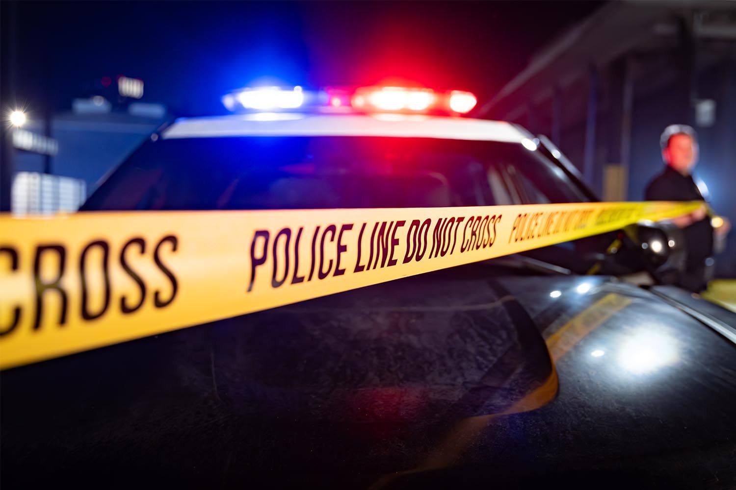 Stock image of police tape and a police carCredit: Getty