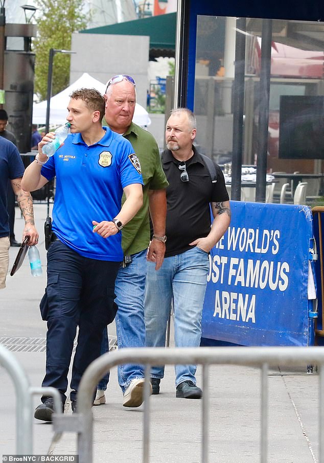 In bombshell new exclusive photographs, Swift's trusted heads of security (middle and right) were pictured outside the iconic venue on Tuesday as preparations for the event ramped up